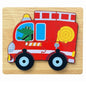 A wooden fire truck jigsaw puzzle set on a light wood background. The puzzle features a red fire truck with white stripes, black wheels with light blue centers, a yellow hose, a yellow light, and a green cartoon frog driver in the window.